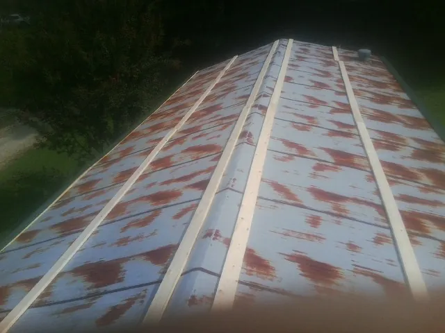 Rusted metal roof panels with new wood purlins before replacement — Storm Damage Roof Repair in Brenham by Roofing Brothers